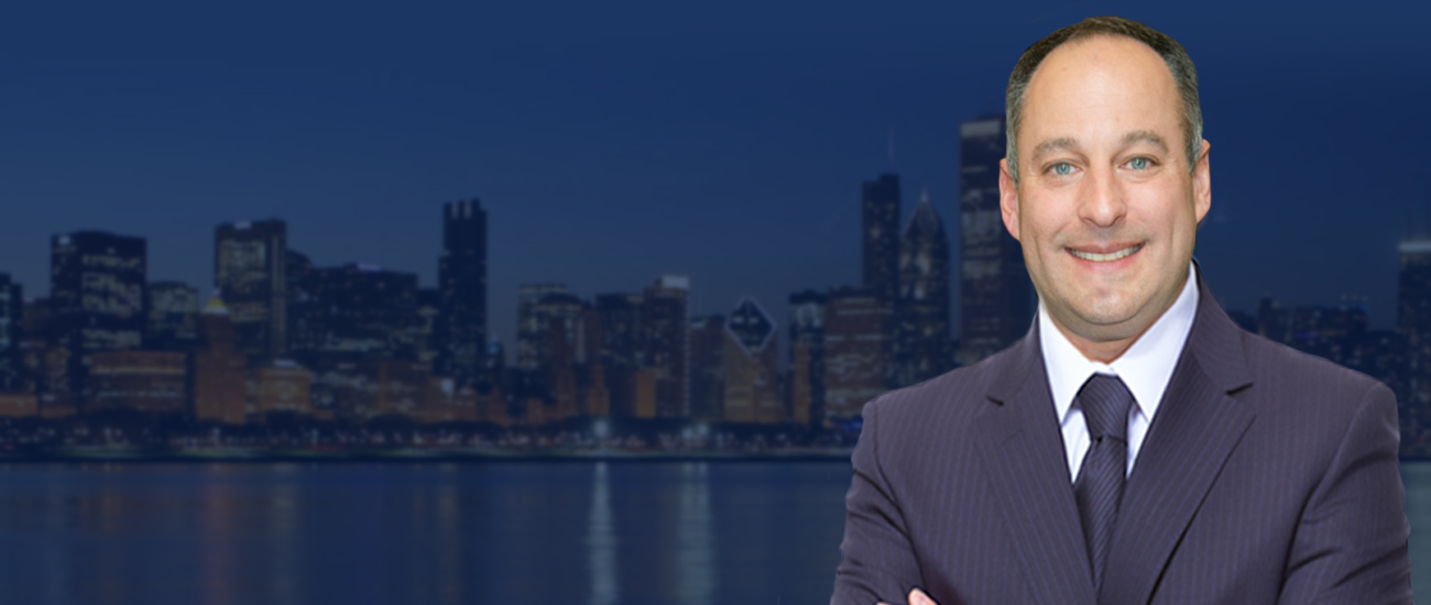 Profile picture of David L. Freidberg in a business suit standing with a city skyline in the background at night.